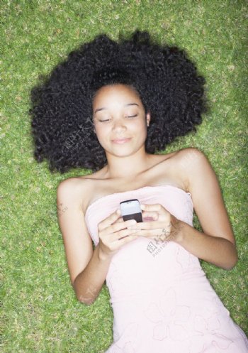 躺在草地上发短信的少女图片