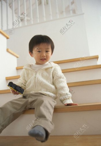 坐在楼梯间的小男孩图片