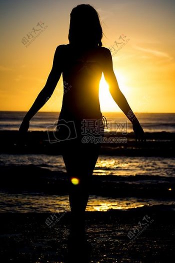 日落时在海滩女子走