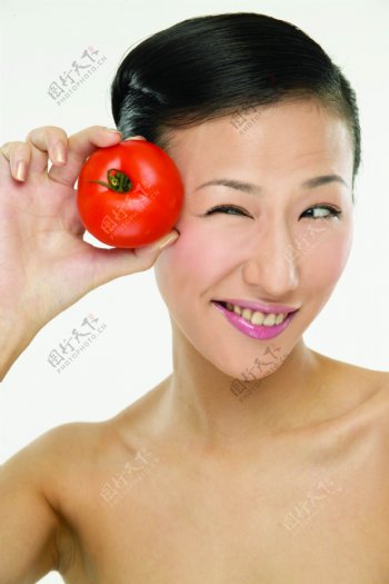 手拿蕃茄的健康女性图片