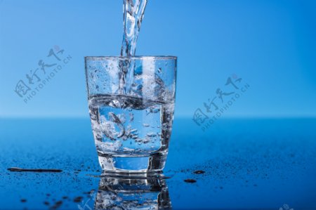 杯子里的冰水与蓝色背景图片