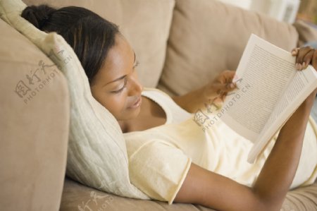 躺在沙发上看书的女性图片
