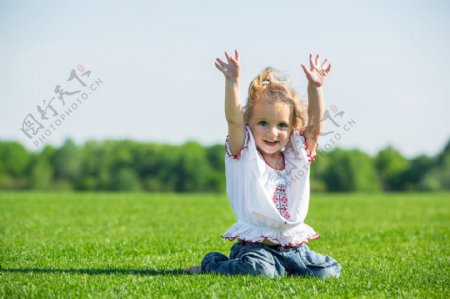 跪在草坪上的小女孩图片