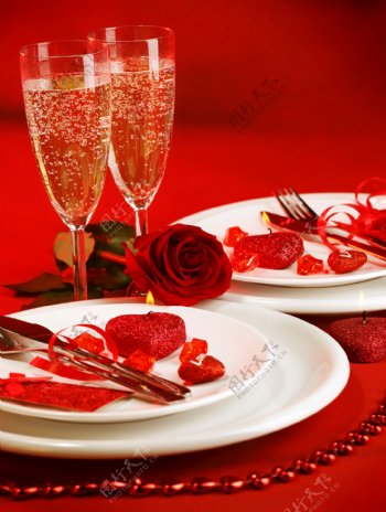 红色桌面上的玫瑰花和酒杯