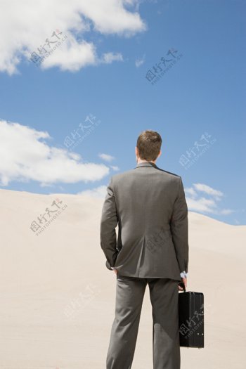 站在沙漠中的商务男人图片