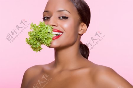 嘴咬青菜的女性图片图片