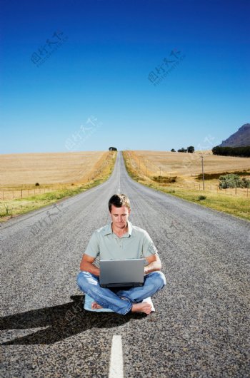 坐在马路上上网的男人图片