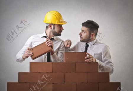 堆砌砖墙的两个工人图片