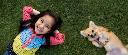 躺在草坪上的小女孩與小狗圖片