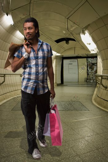 行走在隧道里的购物男性图片