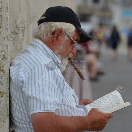 抽烟看书的老年男性