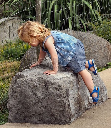 趴在石头上的小女孩