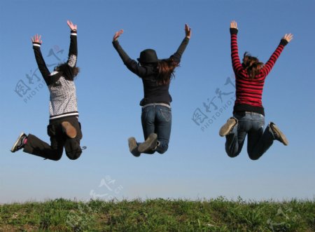跳跃高兴三人群体草地蓝天向往成功