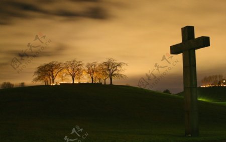 墓地夕阳远景孤独十字架树土丘图片