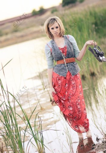 拎着鞋站在湿地里的美女图片