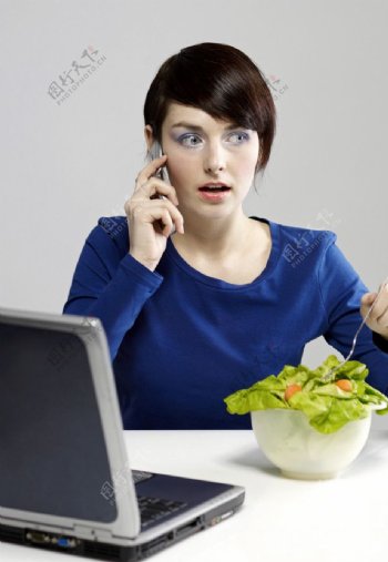 吃蔬菜接电话的美女图片