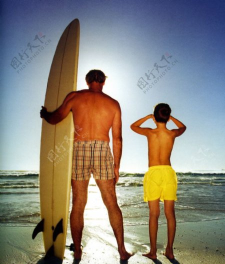 海滩上拿皮艇看海的父子图片