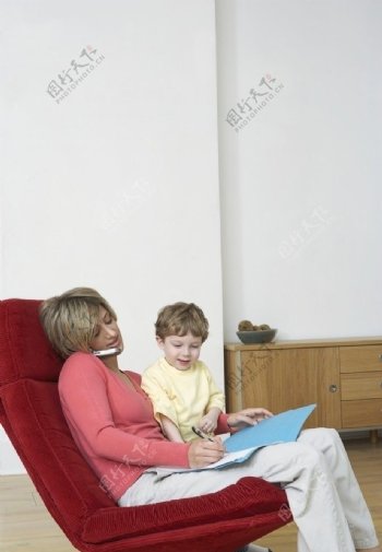 转椅上接电话记录的妈妈和儿子图片