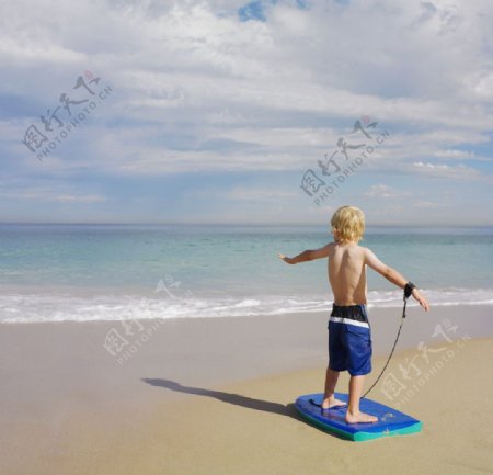 海滩沙滩玩滑板的小帅哥图片