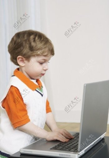 玩笔记本电脑的可爱小男孩图片
