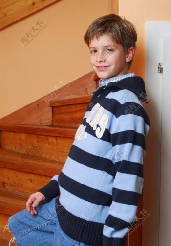 站在楼梯边微笑的男孩图片