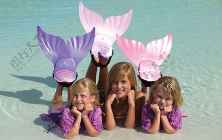 三个小女孩在海边沙滩上扮演美人鱼图片