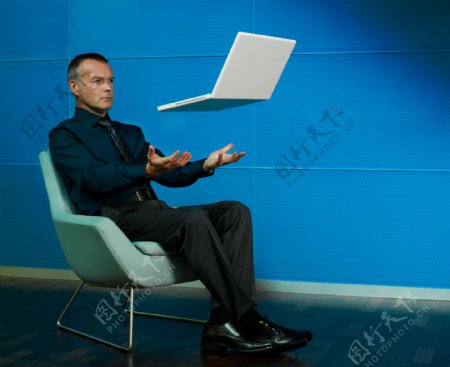 坐在椅子上的男人和笔记本电脑图片