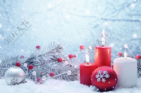 雪中的圣诞树吊饰与蜡烛图片