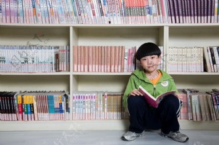 蹲在书架旁的男孩图片图片
