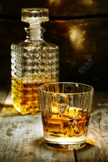 木板上的半瓶威士忌和半杯酒图片