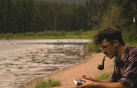 男子身穿黑与白衬衫白使用烟斗