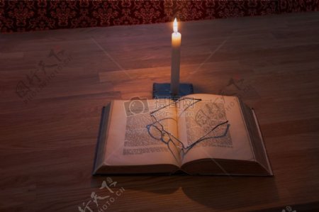 蜡烛下的书本和眼镜