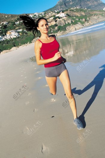 沙滩上跑步的时尚美女图片