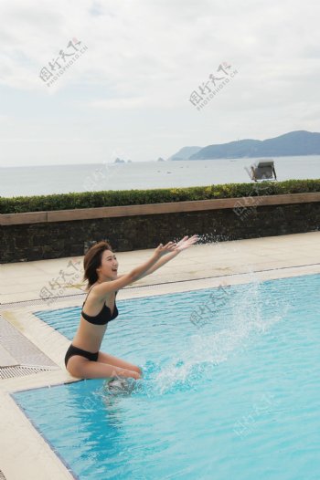 泳池边玩水的美女图片