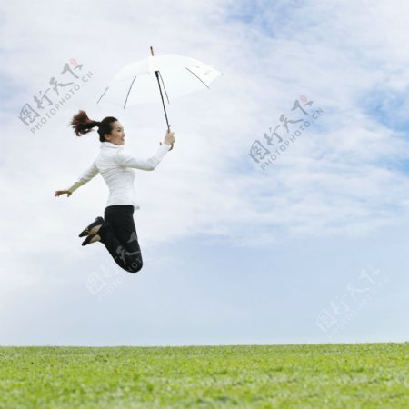 草地上跳跃的女人图片