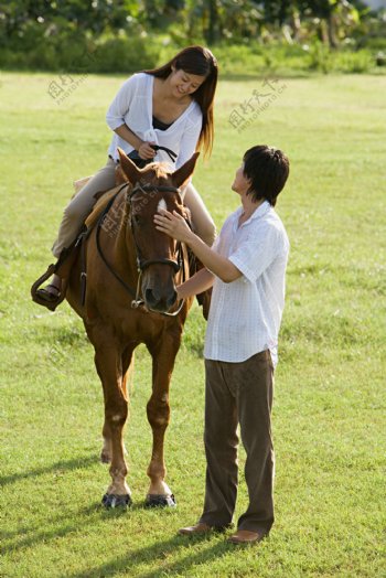 草坪上练习骑马的情侣图片图片