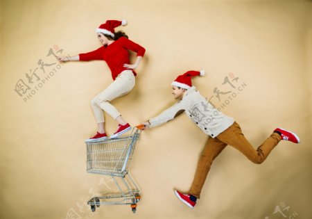 戴着圣诞帽推着购物车的情侣图片