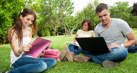 坐在草地上学习看书的学生图片