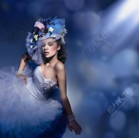 蓝色灯光下穿白色礼服的女人图片