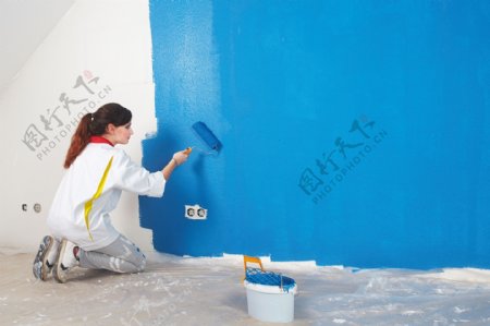 给墙壁粉刷油漆的女人图片