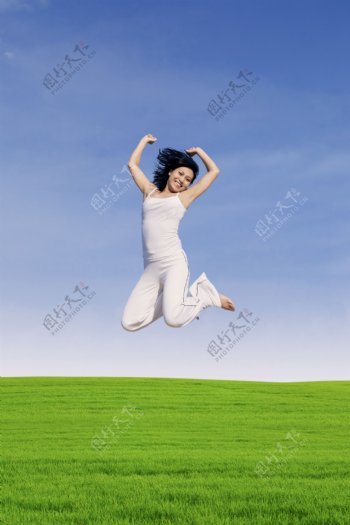 草地上跳跃的美女