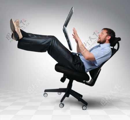 椅子上的男人与笔记本电脑图片