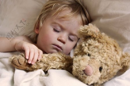 抱着小熊睡觉的小男孩图片