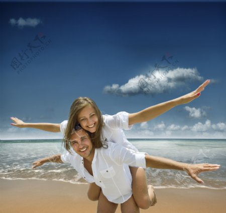 海边作飞翔的情侣图片