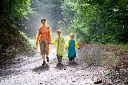 穿着雨衣走在路上的一家人图片