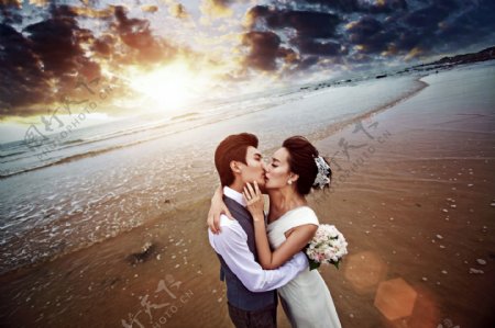 沙滩上接吻的婚纱情侣图片