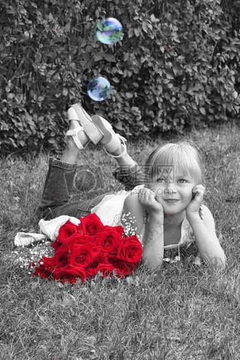 趴草地上女孩和红色的玫瑰