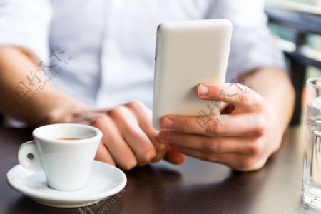 玩手机喝咖啡的商务男人图片