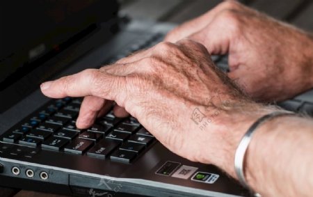 手打字笔记本电脑工作的老人